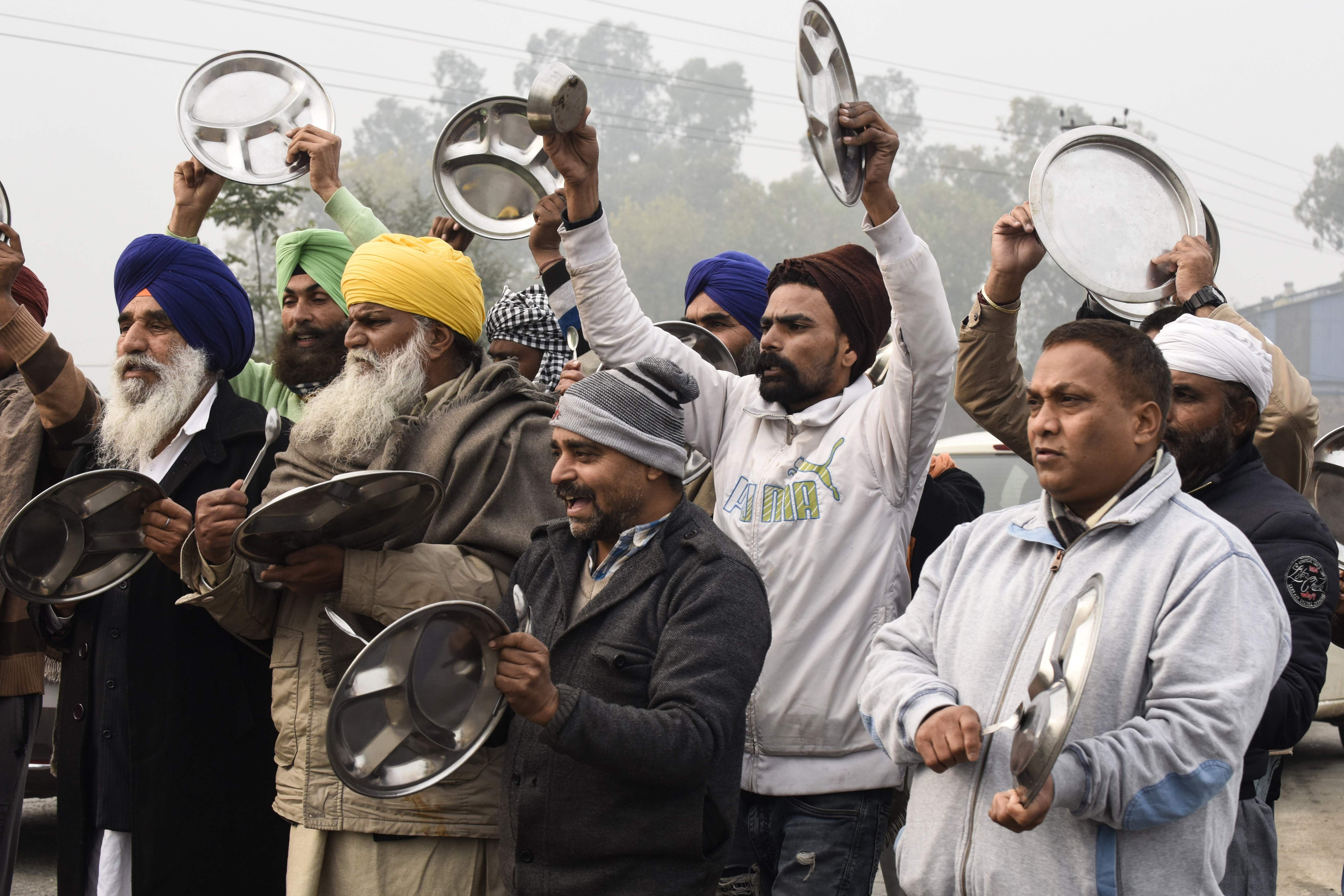 Farmers beat utensils during a protest against the central government's recent agricultural reforms as India's Prime Minister Narendra Modi addressed the nation on the monthly radio programme 'Mann Ki Baat', at the Toll Plaza, on the outskirts of Amritsar on December 27, 2020. Credit: AFP Photo