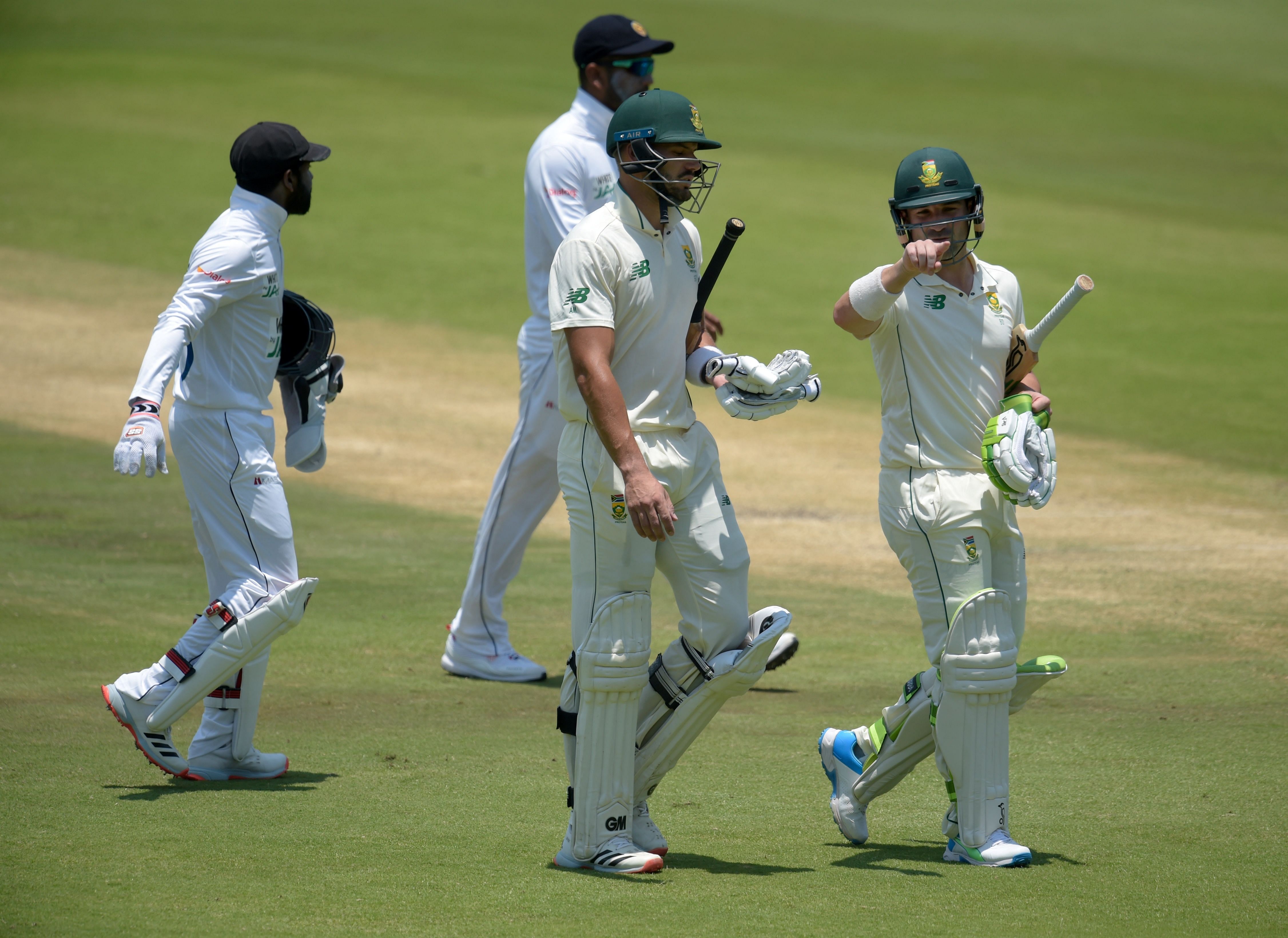 South Africa's Dean Elgar (R) speaks with opening batsman partner South Africa's Aiden Markram (C) as they walk off the field for lunch during the second day of the first Test cricket match between South Africa and Sri Lanka at SuperSport Park in Centurion on December 27, 2020. Credit: AFP Photo