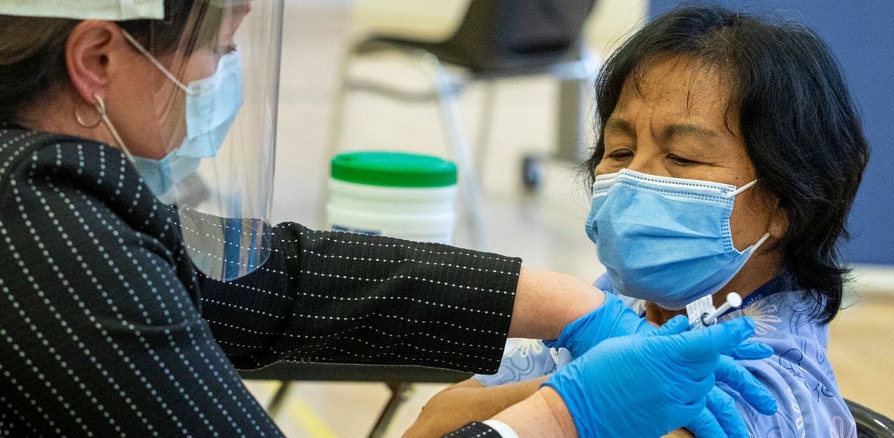 A healthcare worker administers a Pfizer/BioNTEch Covid-19 vaccine to personal support worker Anita Quidangen at The Michener Institute, in Toronto, Canada. Credit: Reuters Photo