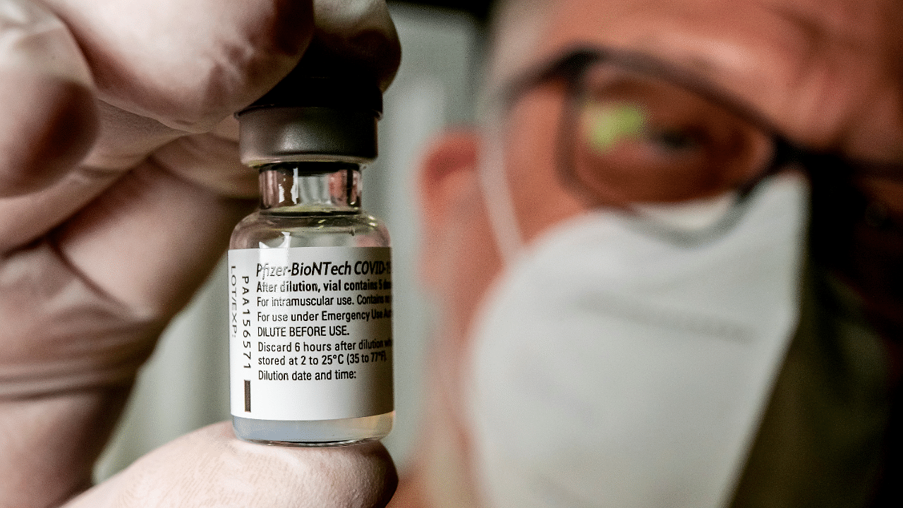 A member of the ASB (Arbeiter-Samariter-Bund) presents a vial with Pfizer-BioNTech Covid-19 vaccine at a vaccination centre in Bad Windsheim. Credit: Reuters Photo
