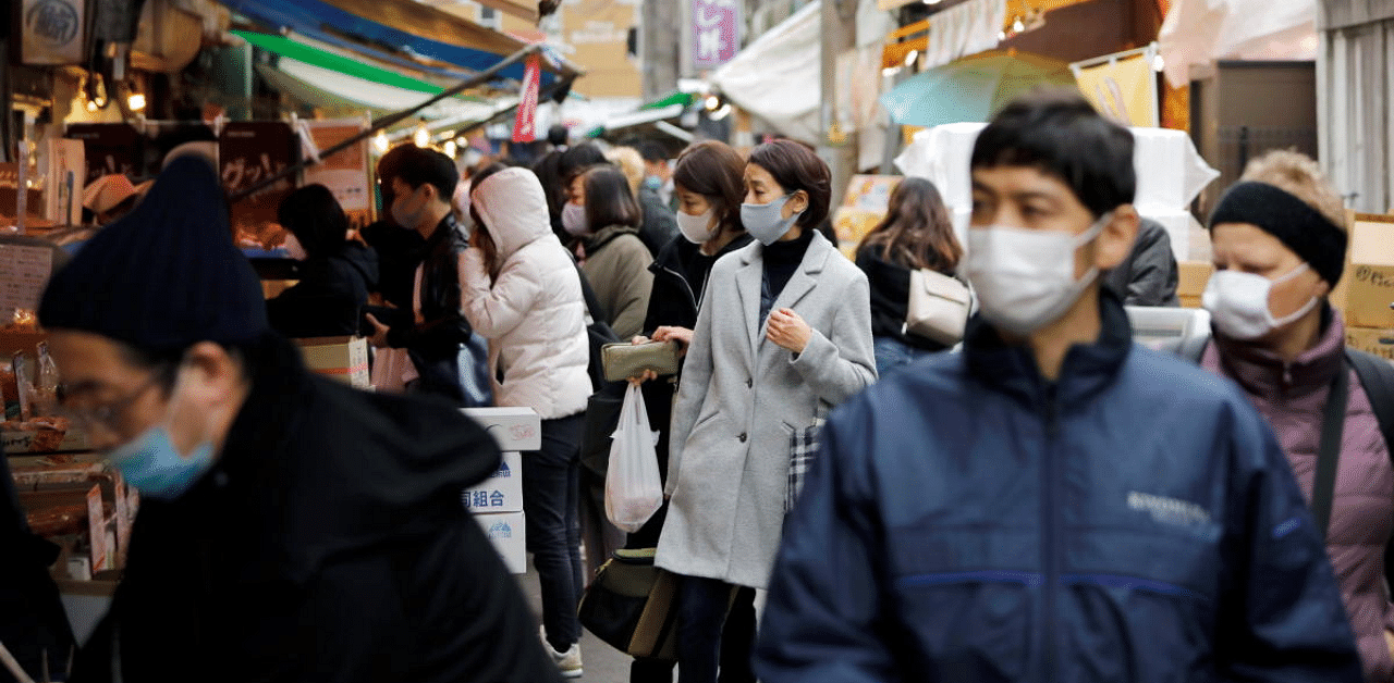 Shoppers wearing protective face masks walk on the street at Tsukiji outer market, amid the coronavirus disease in Japan. Credit: AFP Photo