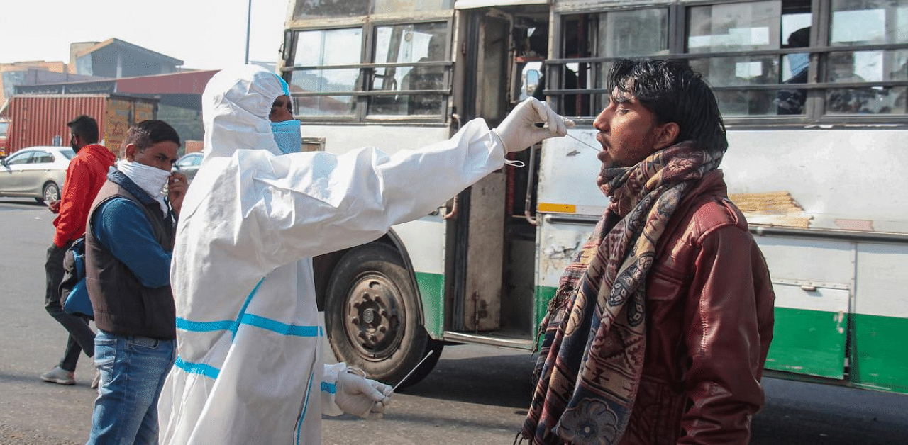 A health worker conducts Covid-19 tests of people coming from other states at Kherki Daula toll plaza, in Gurugram. Credit: PTI