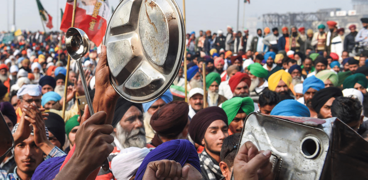 Farmers beat utensils and cans at a protest against PM Modi's Man ki Baat programme, during their ongoing agitation over new farm laws, at Ghazipur border in New Delhi. Credit: PTI Photo