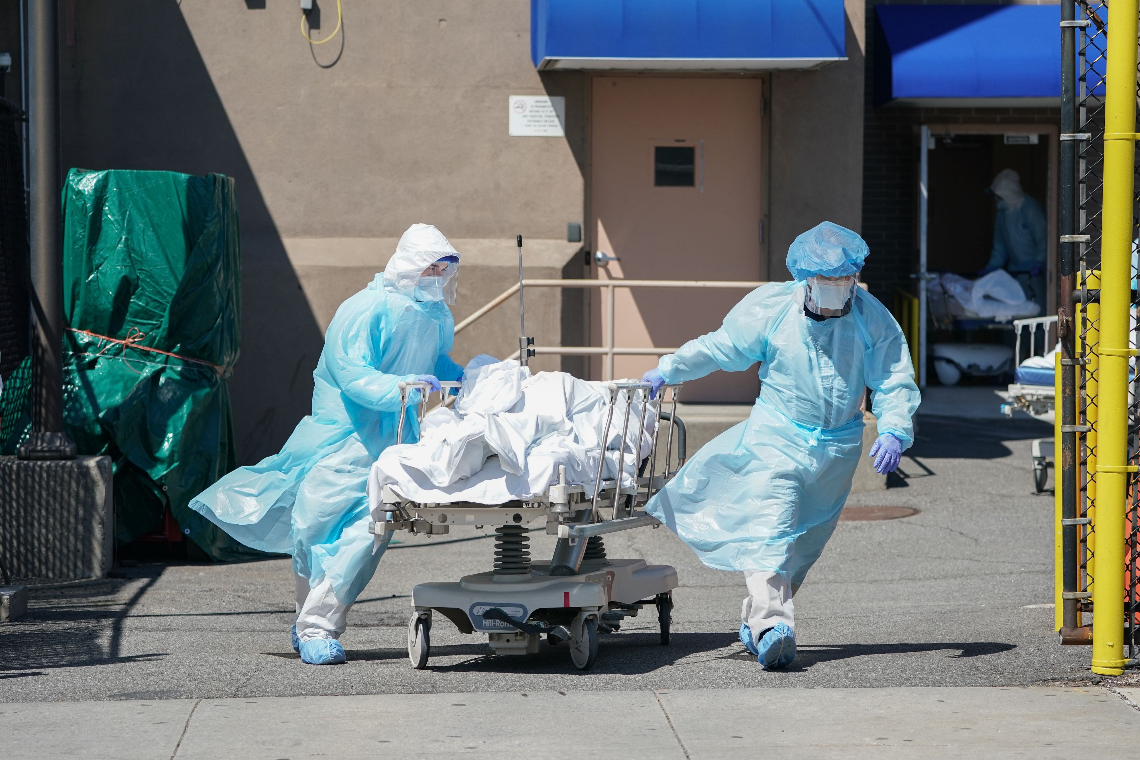 Bodies are moved to a refrigeration truck serving as a temporary morgue at Wyckoff Hospital in the Borough of Brooklyn. Credit: AFP Photo