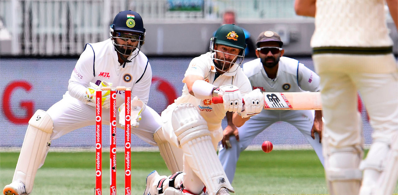 Australia's Matthew Wade (C) sweeps a ball as India's Rishabh Pant (L) and Ajinkya Rahane (R) look on on the third day of the second cricket Test match between Australia and India. Credit: AFP Photo
