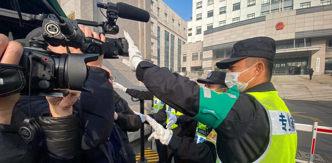 A policeman covers a camera to stop journalists from recording footage outside the Shanghai Pudong New District People's Court, where Chinese citizen journalist Zhang Zhan - who reported on Wuhan's Covid-19 outbreak and placed under detention since May - is set for trial in Shanghai. Credit: AFP. 