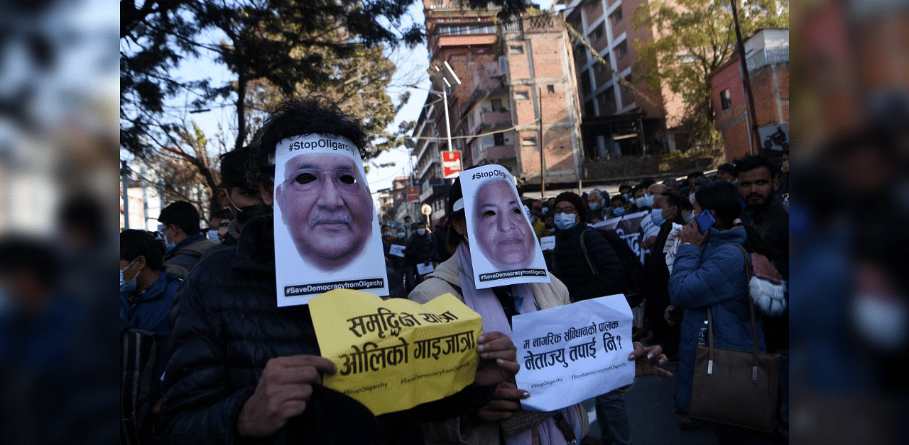 Civil society activists wear facial masks depicting Nepal's President Bidhya Devi Bhandari and Prime Minister K. P. Sharma Oli, during a demonstration against the dissolution of the country's parliament, in Kathmandu on December 26, 2020. Credit: AFP Photo