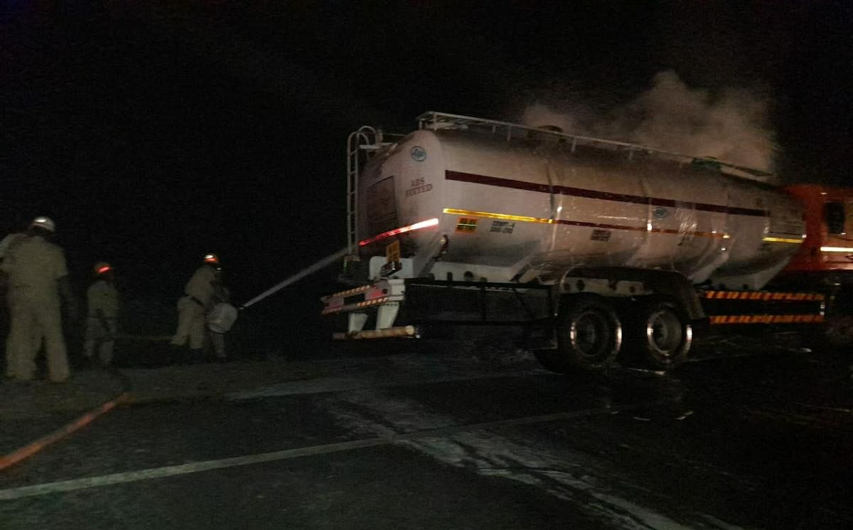 Fire and Emergency services personnel douse fire on the fuel tanker, in Nagamangala taluk, Mandya district, recently.