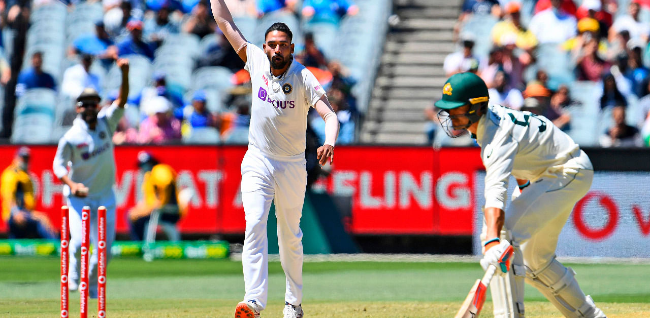 Mohammed Siraj (C) deflects a ball onto the stumps as Australia's Mitchell Starc (R) looks on during the fourth day of the second cricket Test match between Australia and India. Credit: AFP Photo