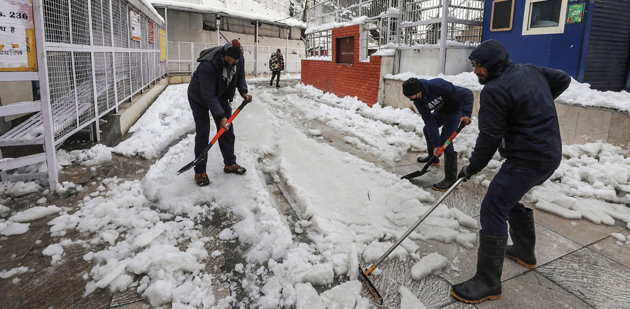 Workers remove snow from the Katra- Mata Vaishno Devi shrine track after heavy snowfall, in Reasi district. Credit: PTI