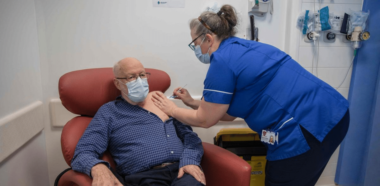 Nurse Naomi Walsh (R) administers the Pfizer-BioNTech Covid-19 vaccine to Roger Shaw, 87, at the Royal Free hospital in London on December 8, 2020 at the start of the UK's biggest ever vaccination programme. Credit: AFP File Photo