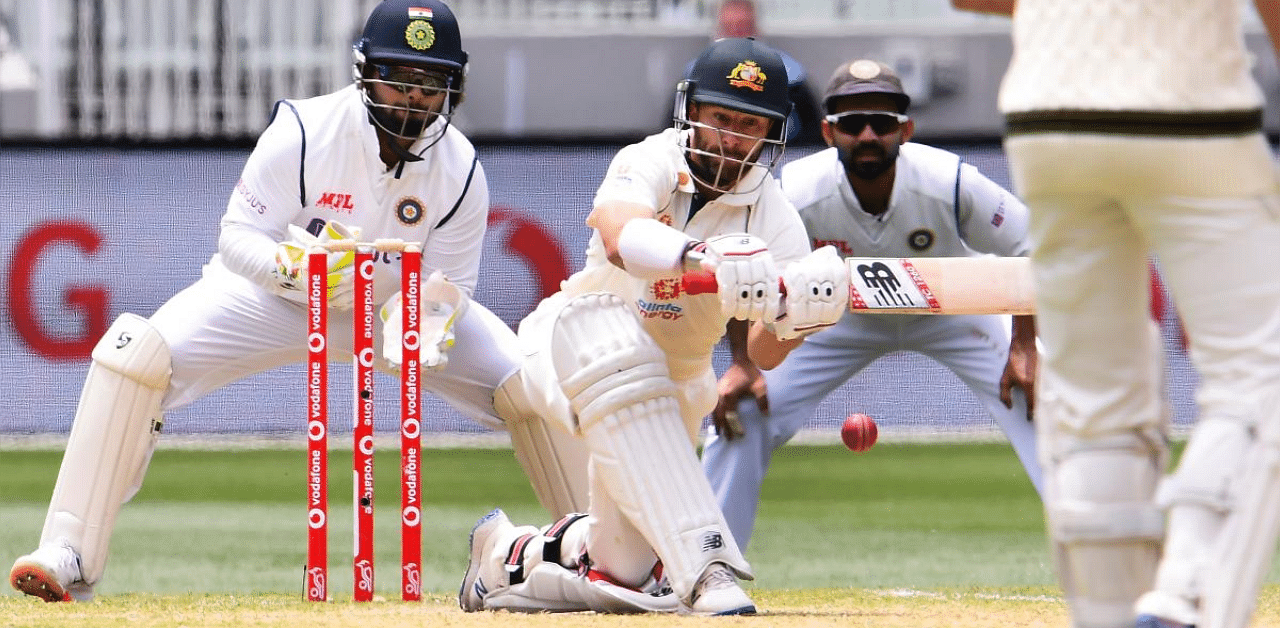 Australia's Matthew Wade (C) sweeps a ball as India's Rishabh Pant (L) and Ajinkya Rahane (R) look on. Credit: AFP. 