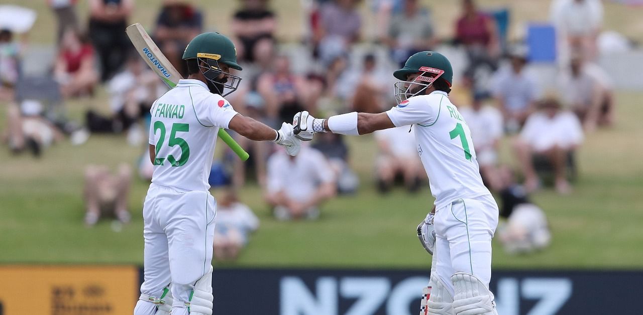 Pakistan's Fawad Alam (L) and Mohammad Rizwan (R) touch gloves during the fifth day of the first cricket Test match between New Zealand and Pakistan at the Bay Oval in Mount Maunganui on December 30, 2020. Credit: AFP Photo