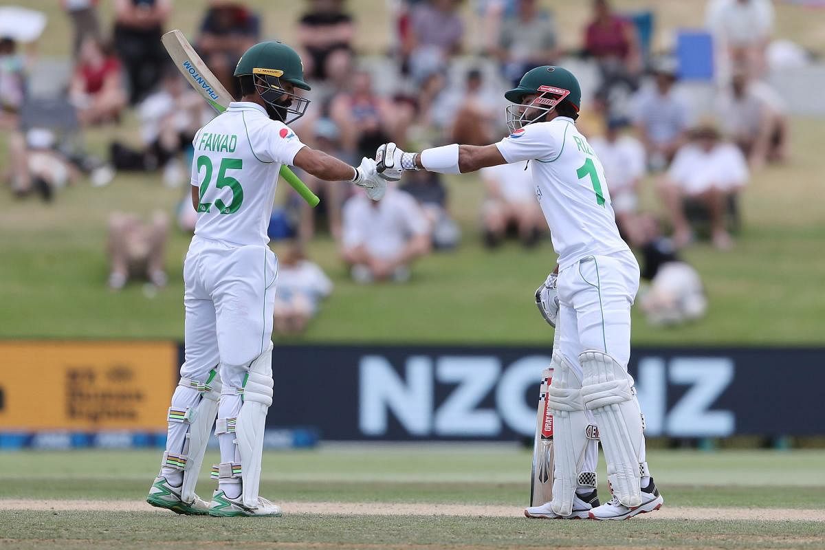 Pakistan's Fawad Alam (L) and Mohammad Rizwan (R) touch gloves during the fifth day of the first cricket Test match between New Zealand and Pakistan at the Bay Oval in Mount Maunganui on December 30, 2020. Credit: AFP. 