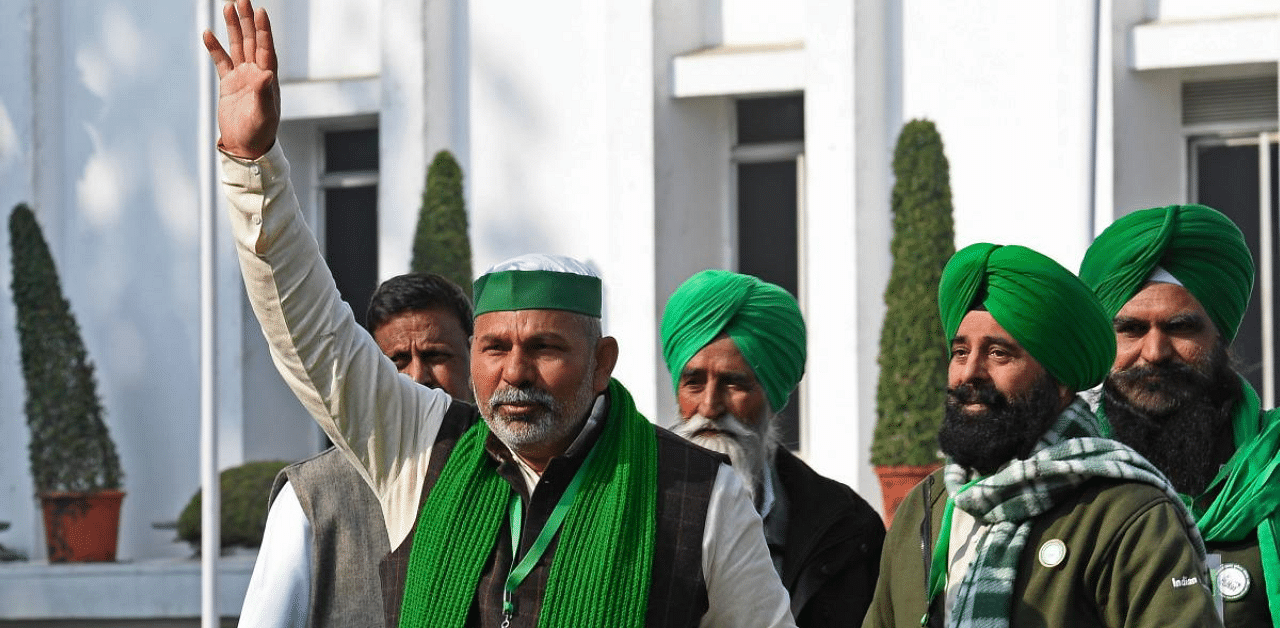 Bhartiya Kisan Union (BKU) leader Rakesh Tikait (2L) waves along with farmers prior to their meeting with Union Ministers. Credit: AFP Photo