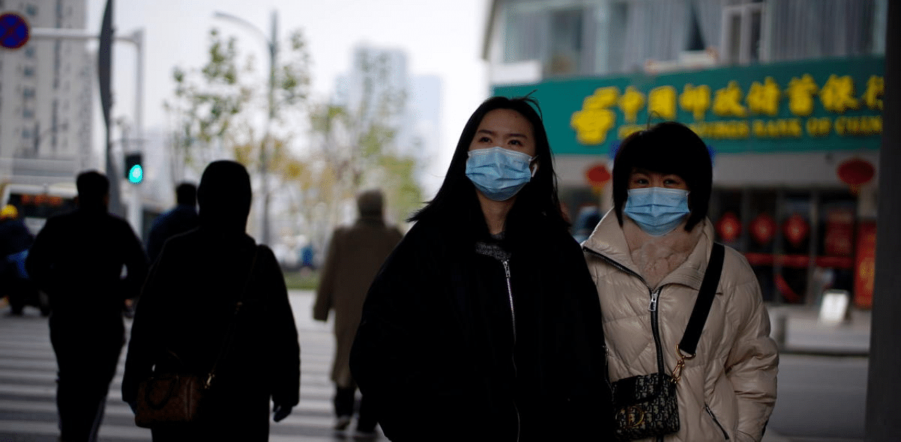 People wearing masks walk across a street, almost a year after the start of the coronavirus disease (Covid-19) outbreak, in Wuhan, Hubei. Credit: Reuters Photo