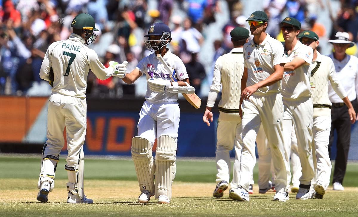India's captain Ajinkya Rahane (2nd L) bumps fists with Australia's captain Tim Paine at the end of the second cricket Test match between Australia and India at the MCG. Credit: AFP. 