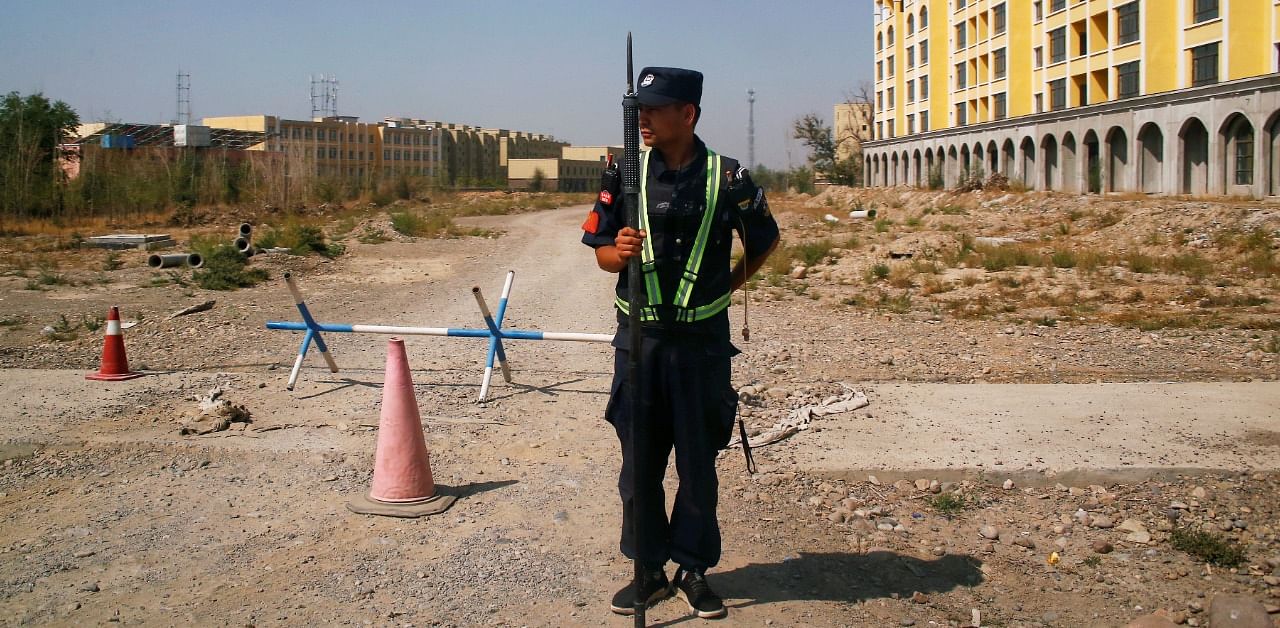 A Chinese police officer takes his position by the road near what is officially called a vocational education centre in Yining in Xinjiang Uighur Autonomous Region, China. Credit: Reuters Photo