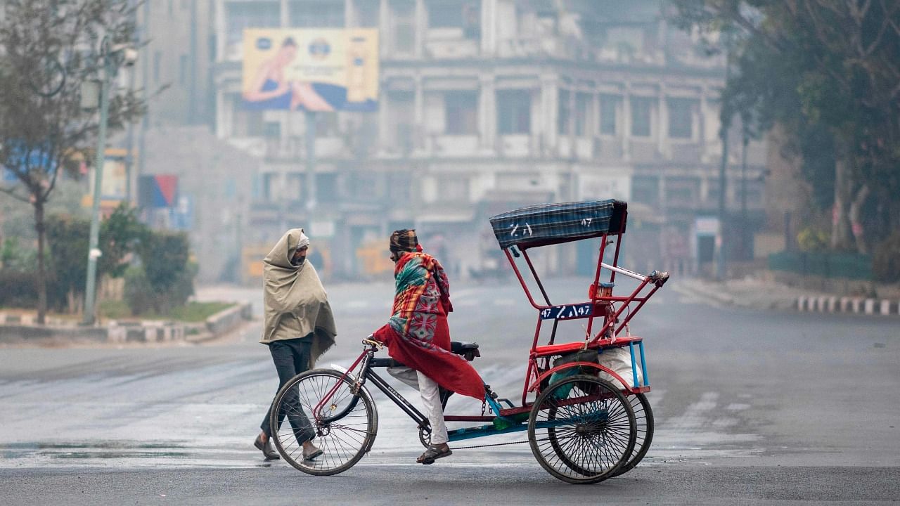 A rickshaw driver rides along a street during a cold winter morning in New Delhi on December 31, 2020. Credit: AFP Photo