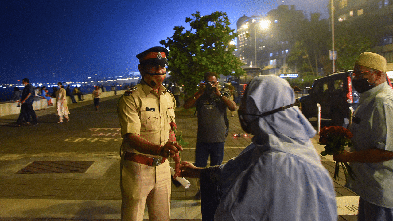 A woman greets a police personnel on duty at the Marine Drive, ahead of New Year celebrations, in Mumbai. Credit: PTI Photo