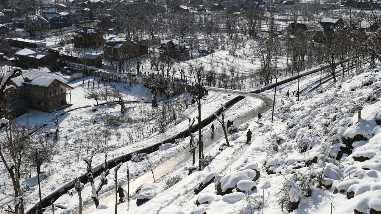 People walk on a road after fresh snowfall at Tangmarg in Baramulla District of north Kashmir. Credit: PTI File Photo