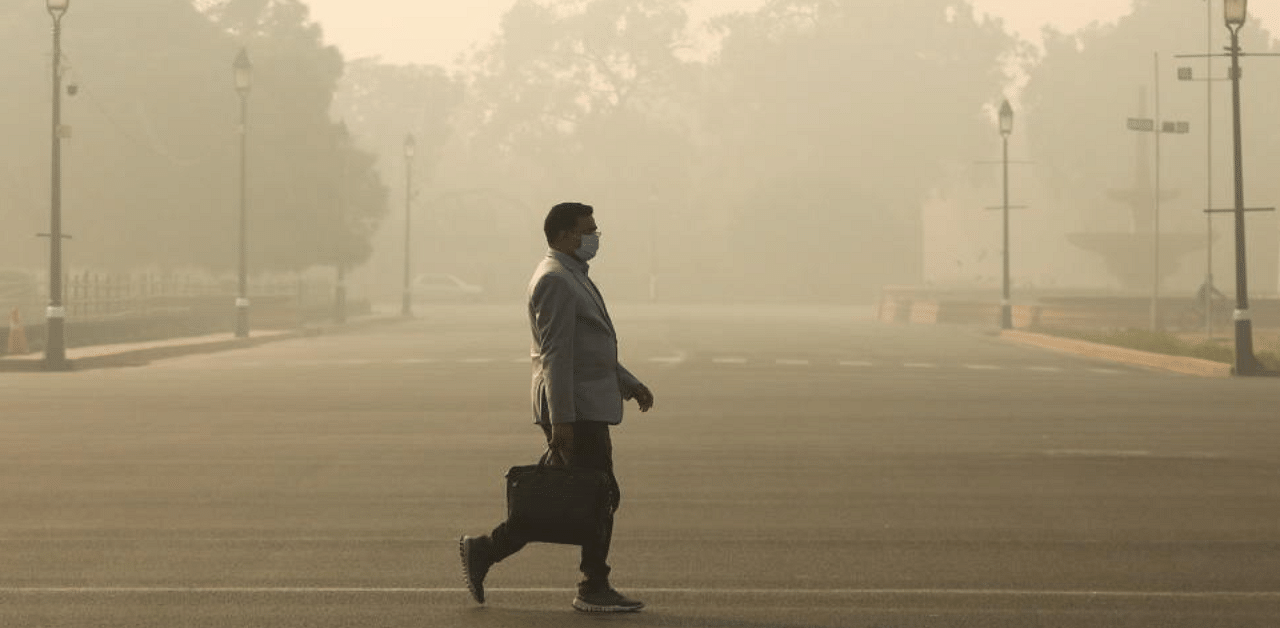 A man walks along a road on a smoggy morning in New Delhi, India, December 23, 2020. Credit: Reuters Photo
