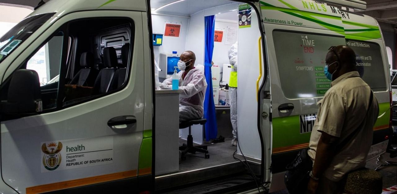 A passenger waits to be tested by a medical staff member of the South Africa Health Department at a mobile testing unit at O.R Tambo International Airport in Ekurhuleni. Credit: AFP.