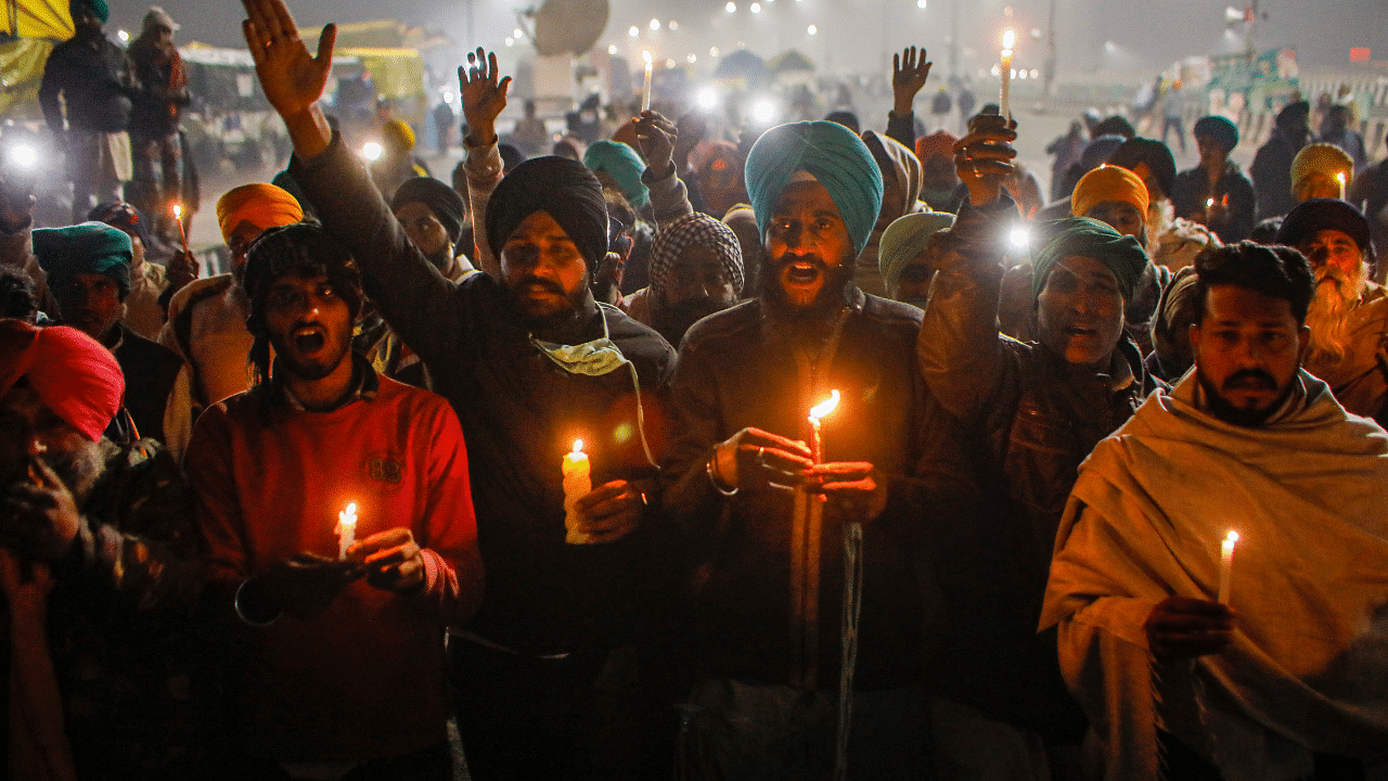 Farmers at Ghazipur border participate in a candlelight vigil in memory of 40 farmers who lost their lives. Credit: PTI Photo