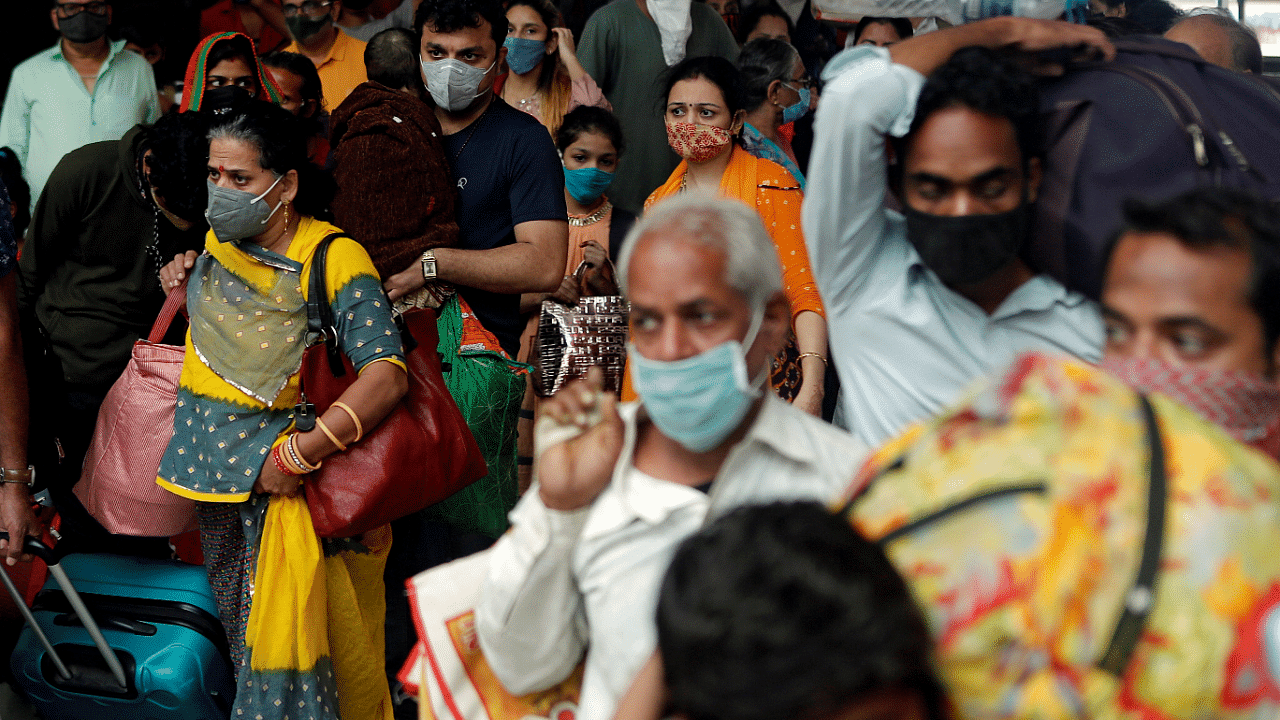 People wearing protective masks exit a railway station amid the spread of the coronavirus disease. Credit: Reuters Photo