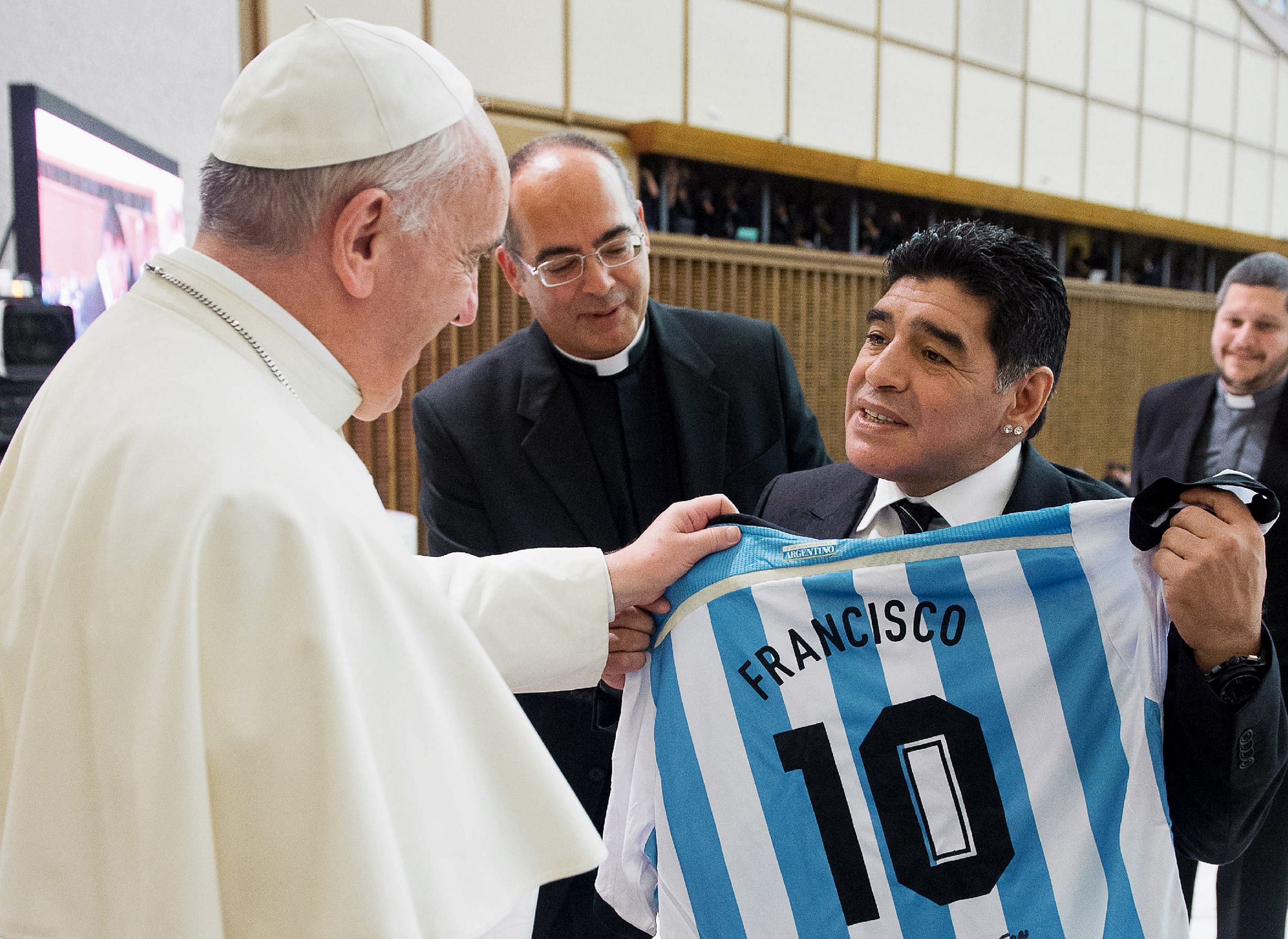 Argentinian former football player Diego Armando Maradona (R) presenting a personalised Argentina jersey to Pope Francis during a meeting with organizers, players and guests of the intereligious "match for peace" football game, in Paul VI hall at the Vatican. - The first pope from Latin America called Diego Maradona a "poet" on the field, as he weighed in on the joys of sport, in a 31-page interview about sports which took place in early December at the Vatican and was published on January 2, 2021 in Italy's La Gazzetta dello Sport. Credit: Vatican press office/AFP