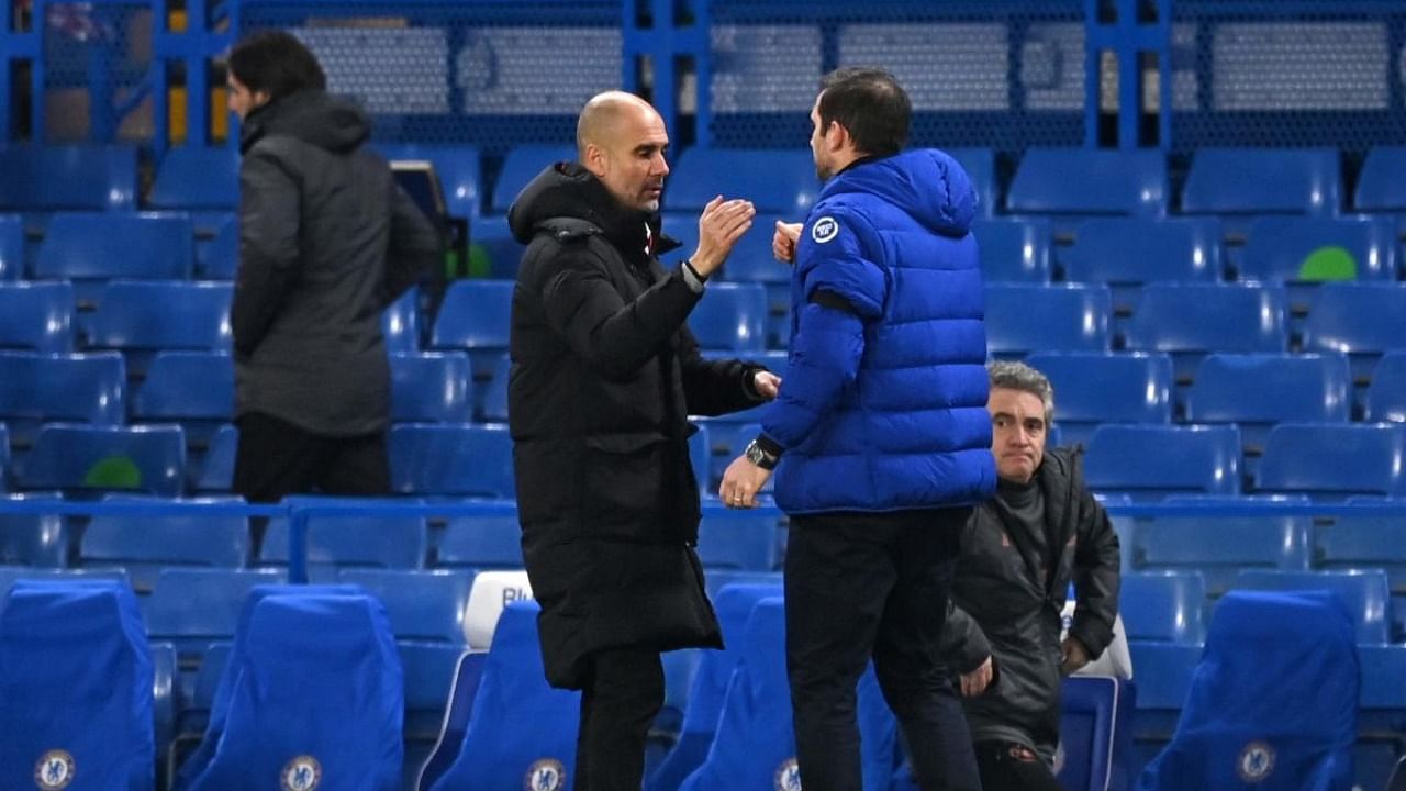 Chelsea's English head coach Frank Lampard (R) shakes hands with Manchester City's Spanish manager Pep Guardiola (L) at the end of the match during the English Premier League football match between Chelsea and Manchester City at Stamford Bridge in London. Credit: AFP.