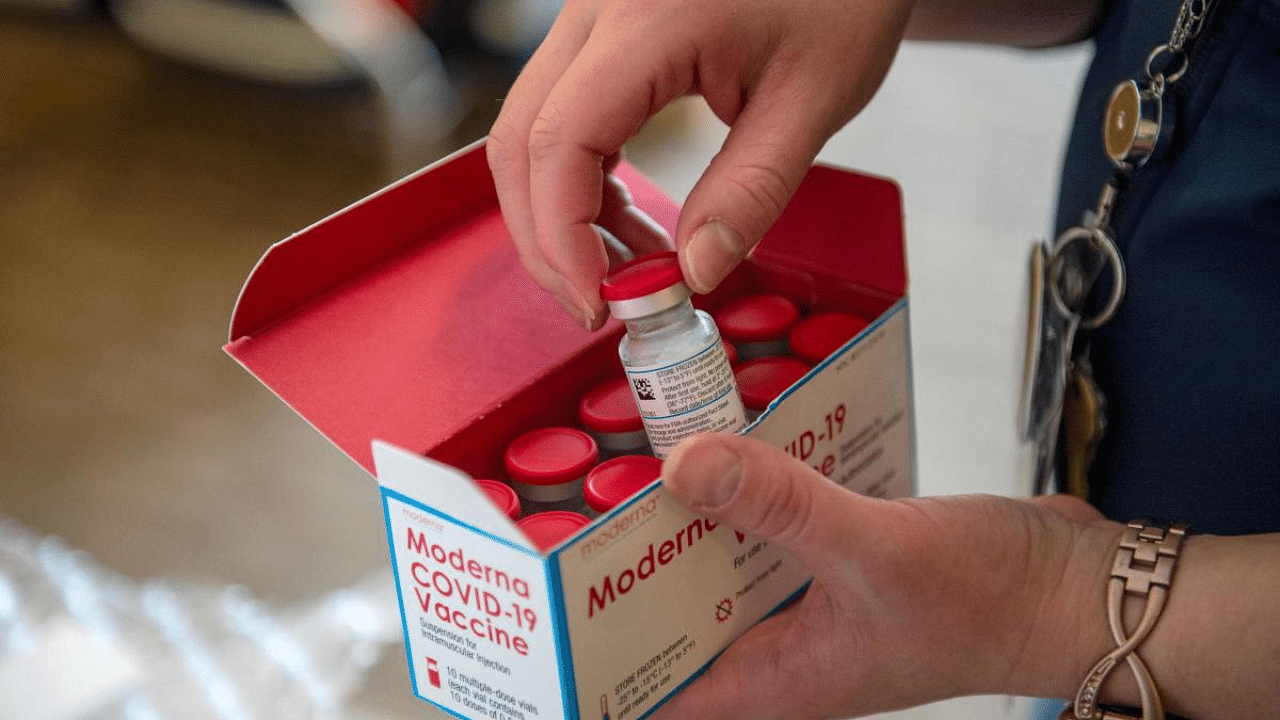 A person unpacks a special refrigerated box of Moderna Covid-19 at the East Boston Neighborhood Health Center (EBNHC) in Boston, Massachusetts. Credit: AFP File Photo