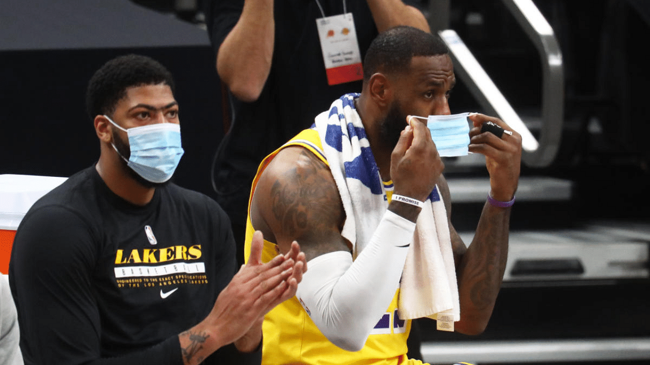 Los Angeles Lakers forward LeBron James (23) puts on a face mask on the bench alongside forward Anthony Davis (3). Credit: USA Today Sports Photo