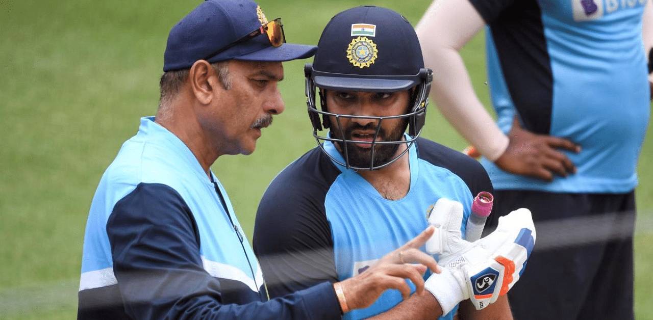 Rohit Sharma (R) chats with team coach Ravi Shastri (L) during a training session. Credit: AFP Photo