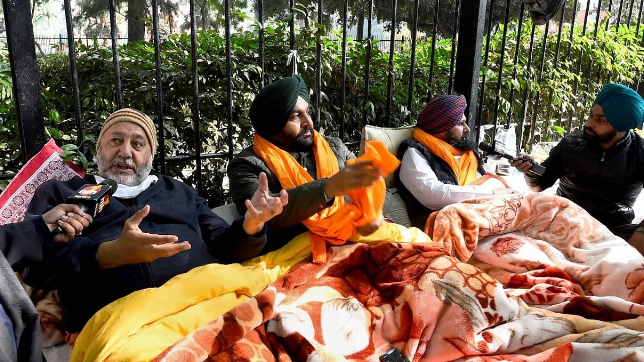 Congress MP's from Punjab Jasbir Singh Gill (L), Gurjit Singh Aujla (C), along with others sit on a dharna demanding the withdrawal of new farm laws and to hold the Winter Session of Parliament, at Jantar Mantar in New Delhi. Credit: PTI file photo.