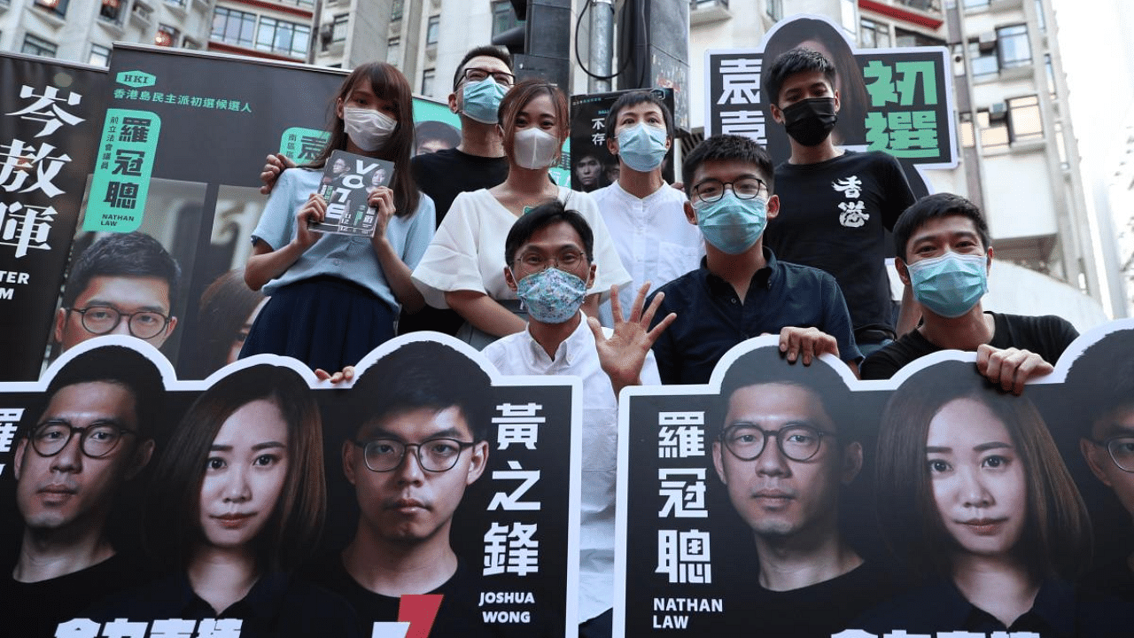 (Back row L-R) Agnes Chow, Anthony Wong, Tiffany Yuen, Denise Ho, Lester Shum, (front row L-R) Eddie Chu, Joshua Wong, and Gregory Wong pose while campaigning during a primary election in Hong Kong. Credit: AFP File Photo
