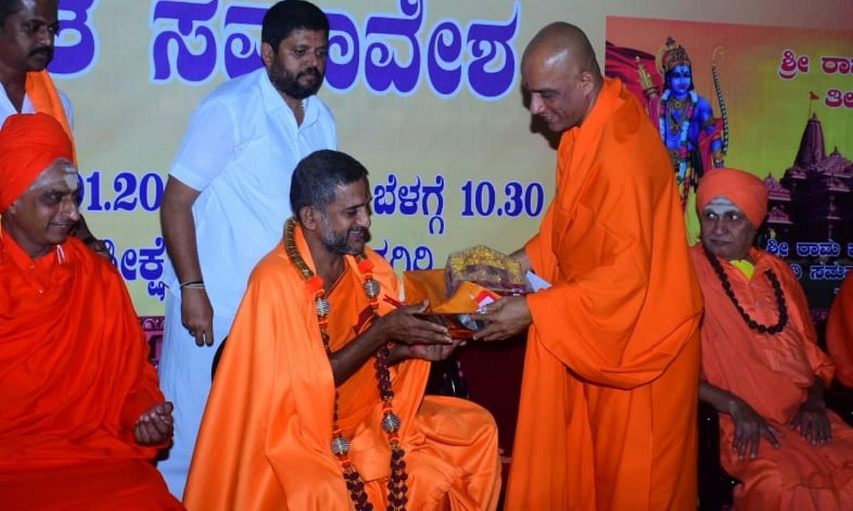 Adichunchanagiri seer Nirmalanandanatha Swami greets Pejawar seer Vishwaprasanna Theertha Swami, during his visit to Nagamangala taluk on Wednesday. Credit: DH.