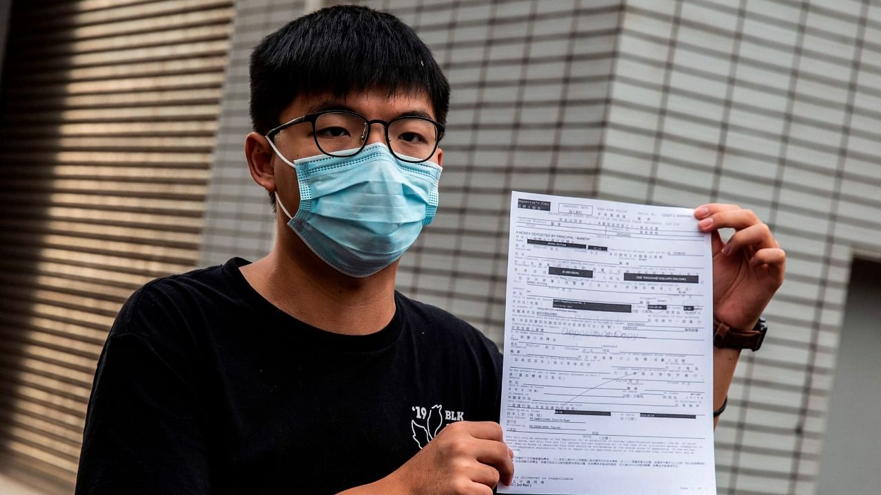 In this file photo taken on September 24, 2020 pro-democracy activist Joshua Wong speaks to the media while holding up a bail document after leaving Central police station in Hong Kong, after being arrested for unlawful assembly related to a 2019 protest against a government ban on face masks. Credit: AFP Photo