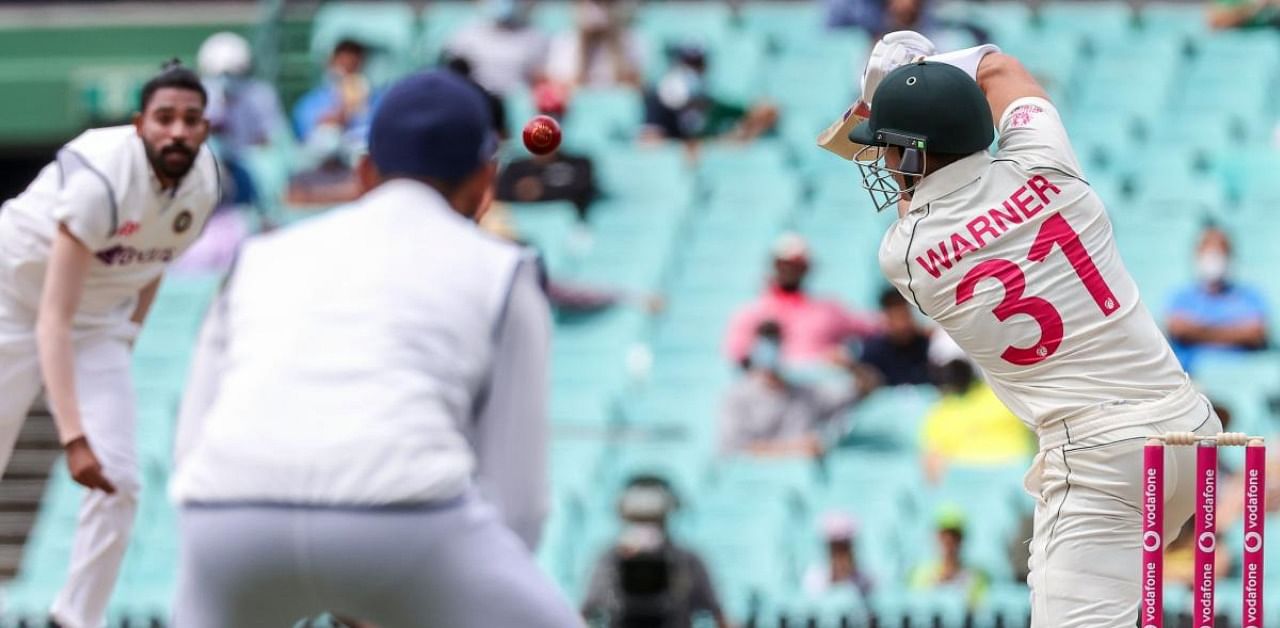 Australia’s David Warner (R) hits a shot and is dismissed by India’s Mohammed Siraj (L) during on day one of the third cricket test match at the Sydney Cricket Ground (SCG) between Australia and India on January 7, 2021. Credit: AFP Photo