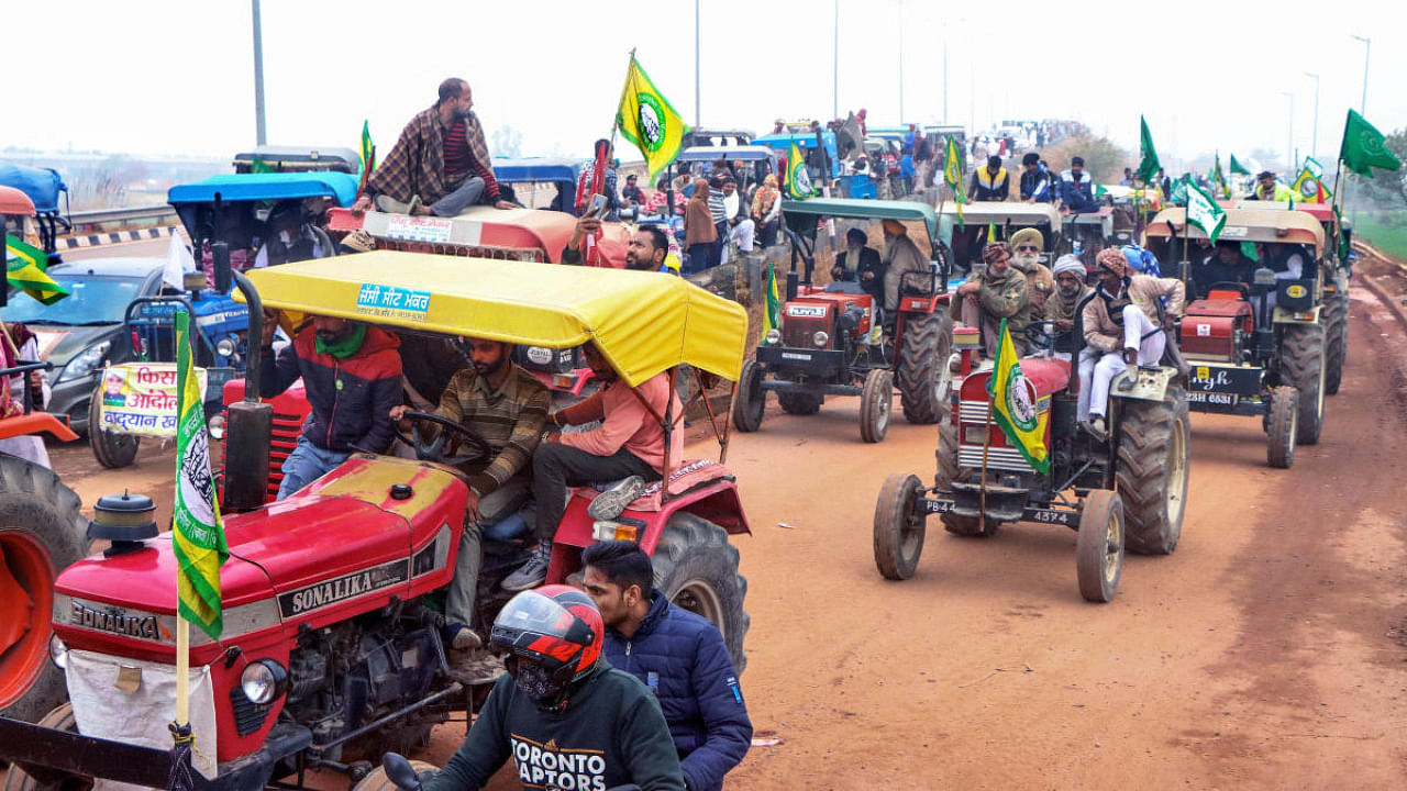 Farmers hold a tractor rally during their ongoing protest against the new farm laws, at KMP Expressway near Haryana-Delhi border in Jhajjar district. Credit: PTI.