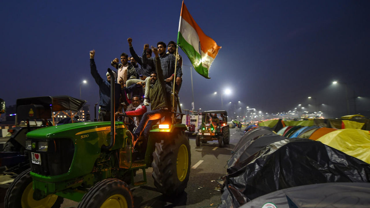Farmers on tractors raise slogans during their protest over Centre's farm reform laws, at the Delhi-UP border near Ghazipur, in New Delhi. Credit: PTI.