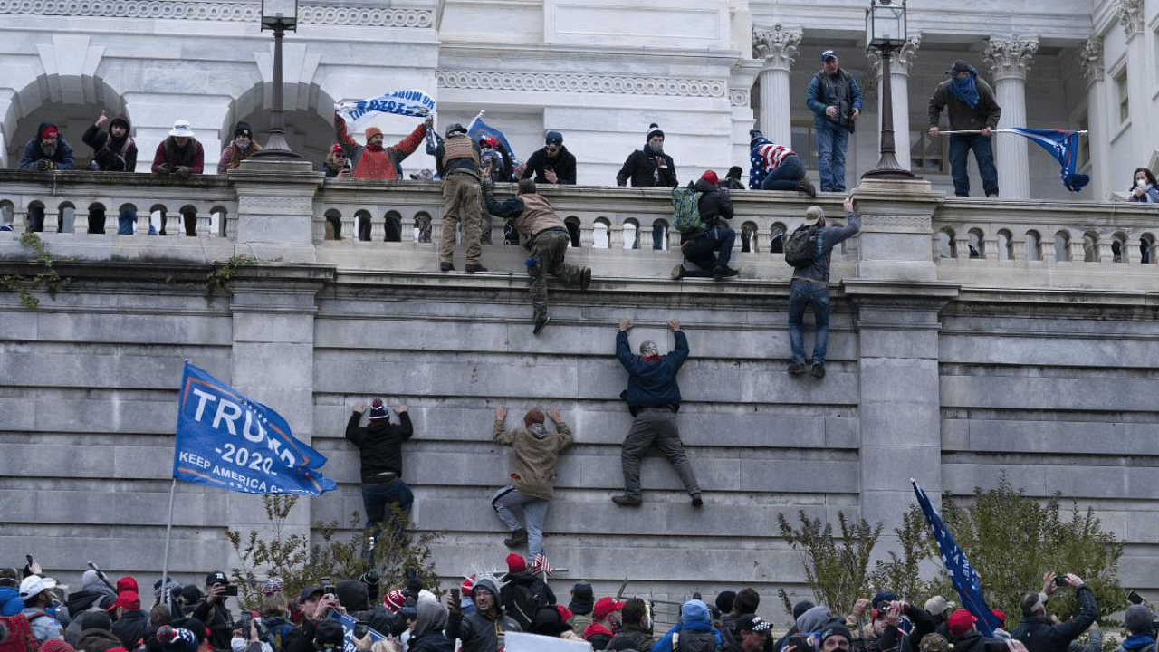 Supporters of President Donald Trump climb the west wall of the the US Capitol on Wednesday in Washington. Credit: AP/PTI Photo