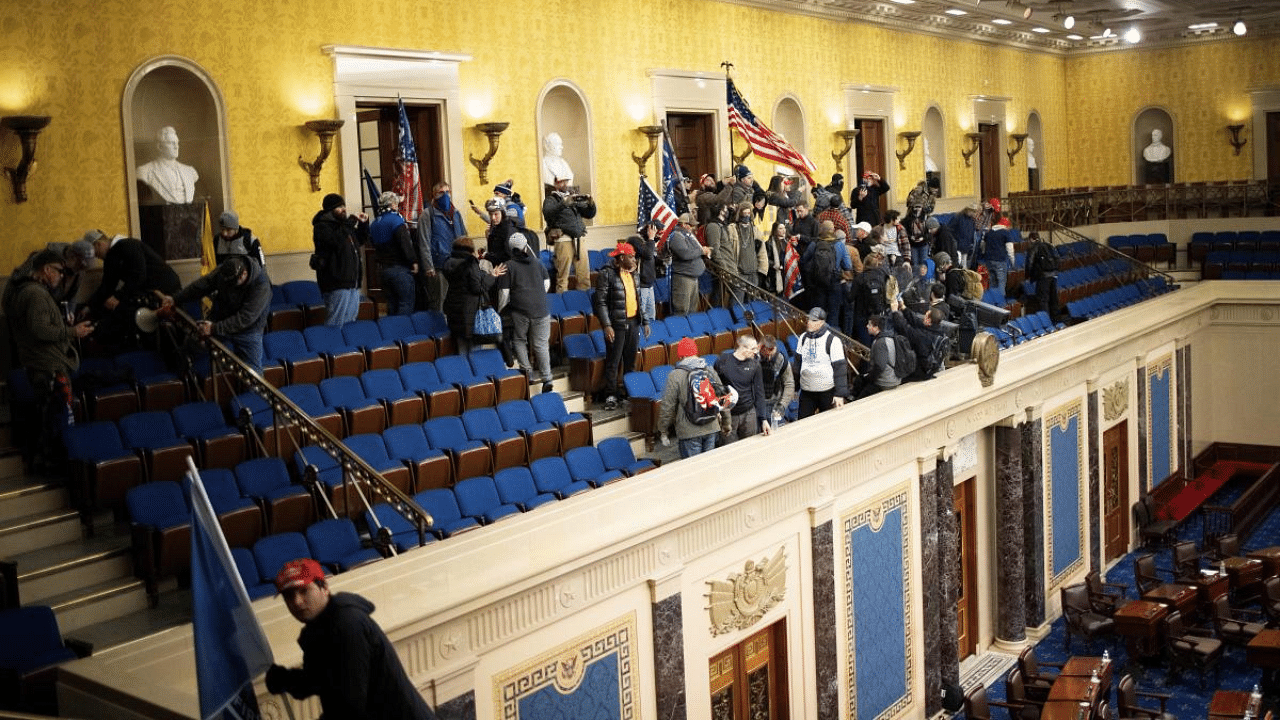 A pro-Trump mob gathers inside the Senate chamber in the U.S. Capitol after groups stormed the building in Washington, DC. Credit: AFP Photo