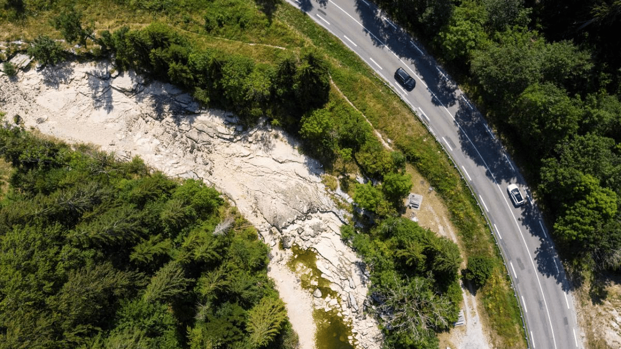 An aerial view of La Longeville, eastern France, with cars passing by the dry Doubs river as a heatwave hits France. Credit: AFP File Photo