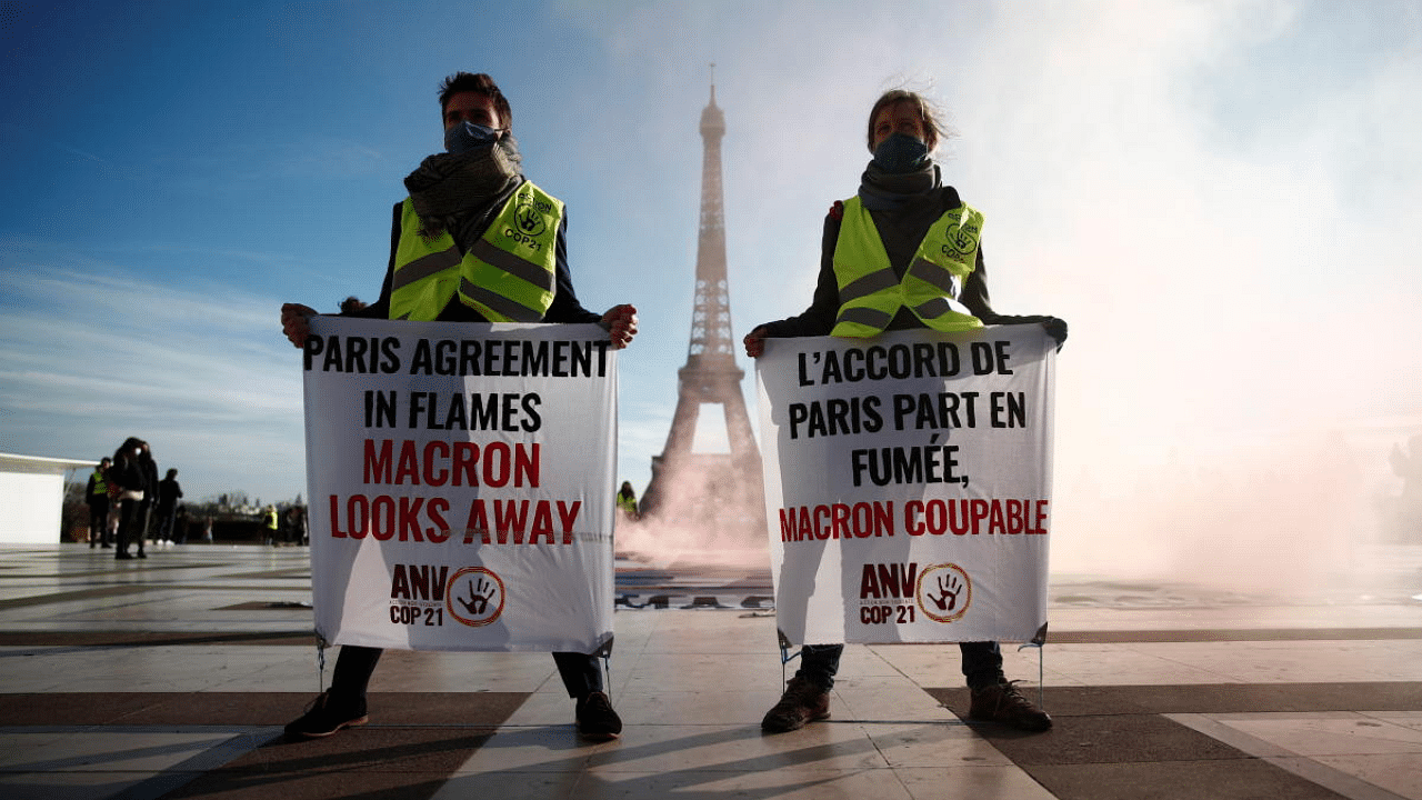 Climate activists demonstrate in front of the Eiffel tower to mark the fifth anniversary of the 2015 United Nations Paris Agreement on climate change, in Paris, France. Credit: Reuters File Photo