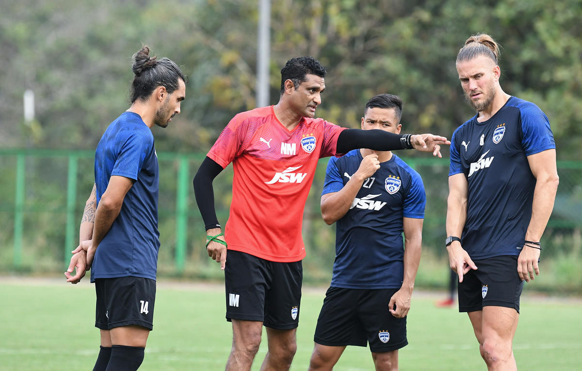 Bengaluru FC’s interim head coach Naushad Moosa (centre) interacts with Dimas Delgado (left), Erik Paartalu (right) and Suresh Wangjam during a training session on Friday. 