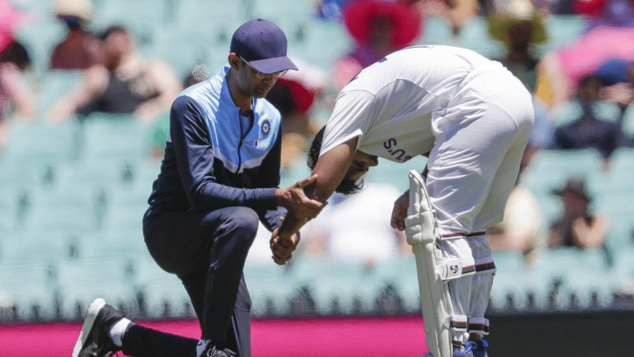 India's Rishabh Pant, right, receives treatment to his arm after he was hit while batting during play on day three of the third cricket test between India and Australia at the Sydney Cricket Ground, Sydney, Australia. Credit: AFP Photo
