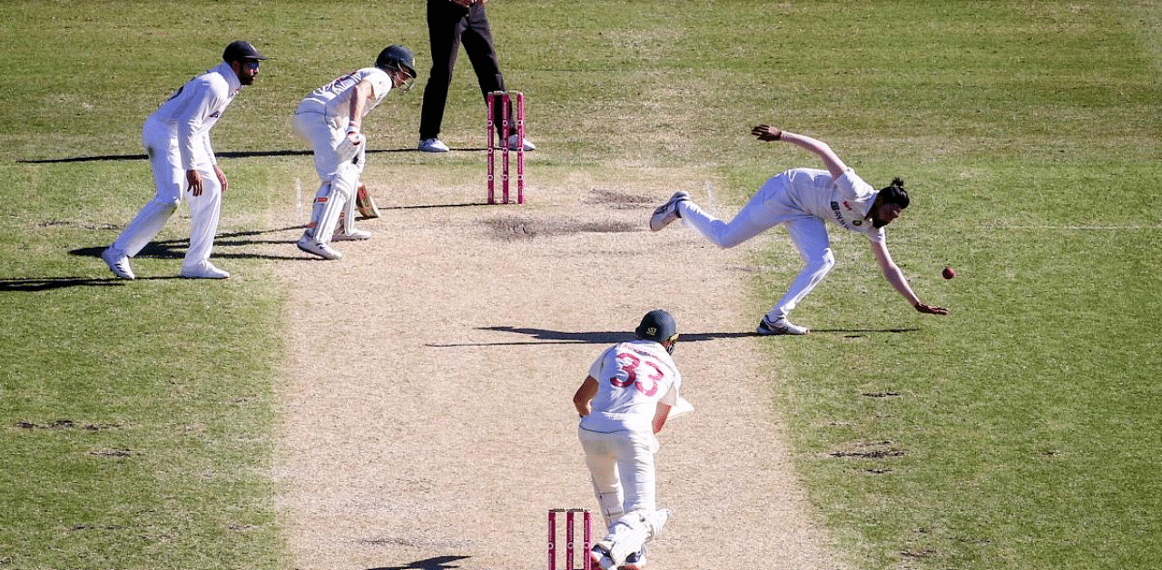 India's Mohammed Siraj (R) reaches to stop a shot from Australia's Marnus Labuschagne. Credit: AFP Photo