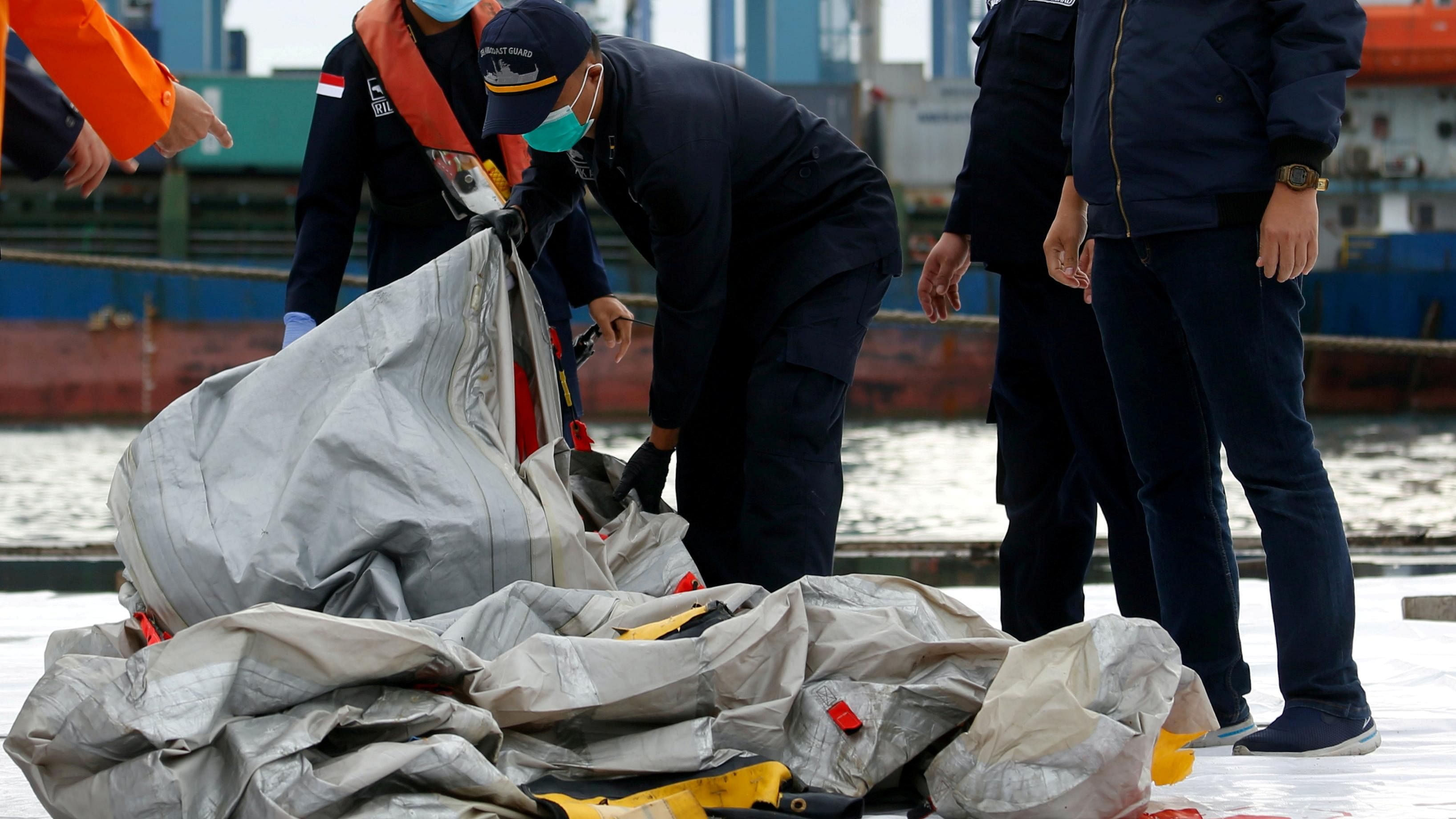 Indonesian rescue members carry what is believed to be the remains of the Sriwijaya Air plane flight SJ182 which crashed into the sea, at Jakarta International Container Terminal port in Jakarta, Indonesia. Credit: Reuters