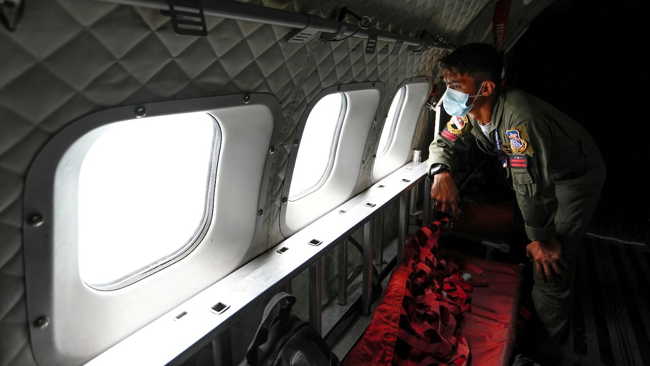 An Indonesian Air Force personnel looks through the window of a CN-295 aircraft during an aerial search for the Sriwijaya Air SJ-182, which crashed to the sea, in Jakarta, Indonesia. Credit: Reuters Photo